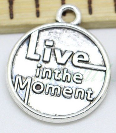 bedel met tekst: 'Live in the moment'